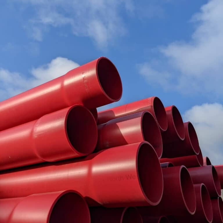 Red cylinders piled on each other, with a blue sky in the background